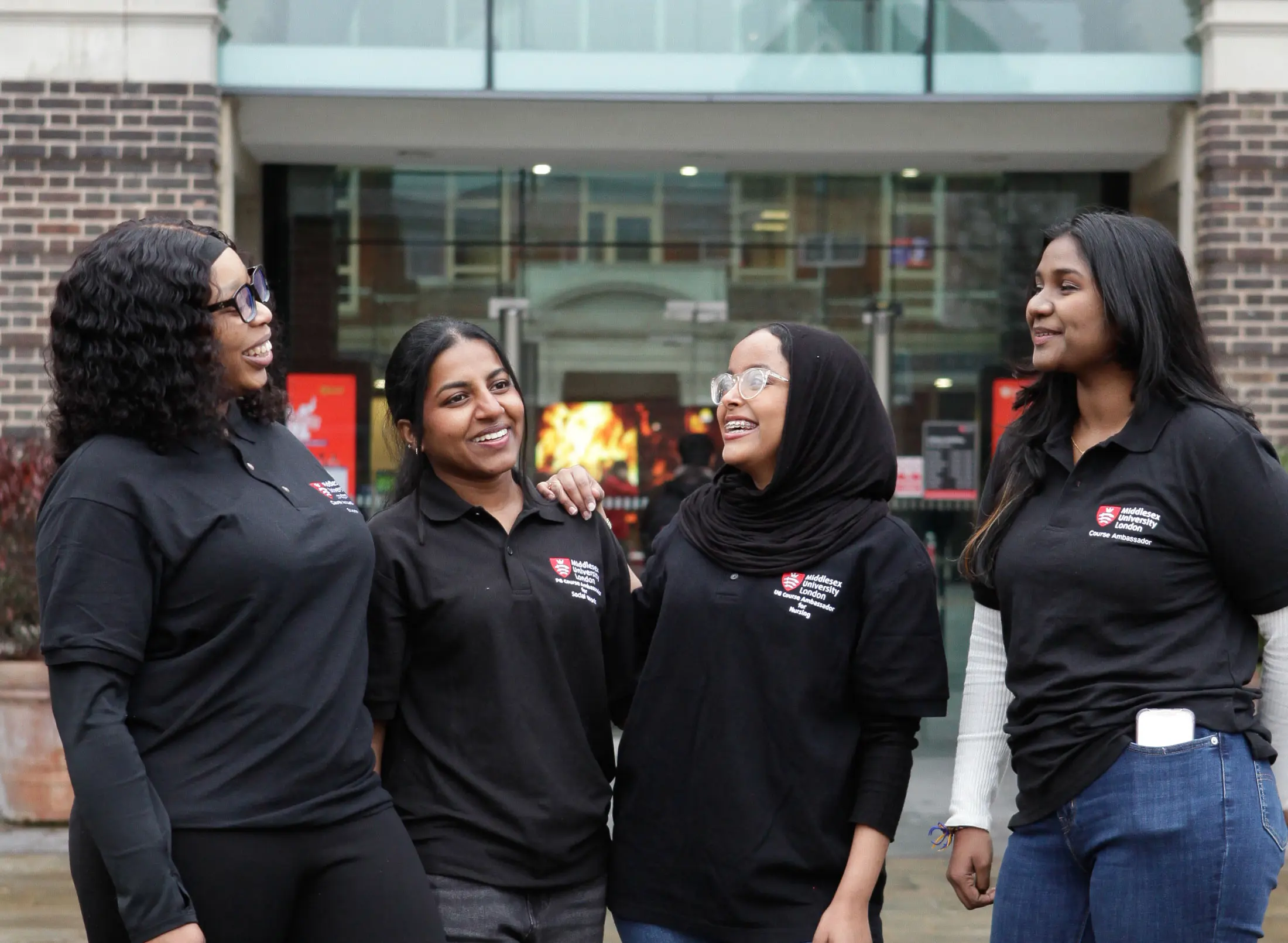 A group of 4 student ambassadors chatting outside campus