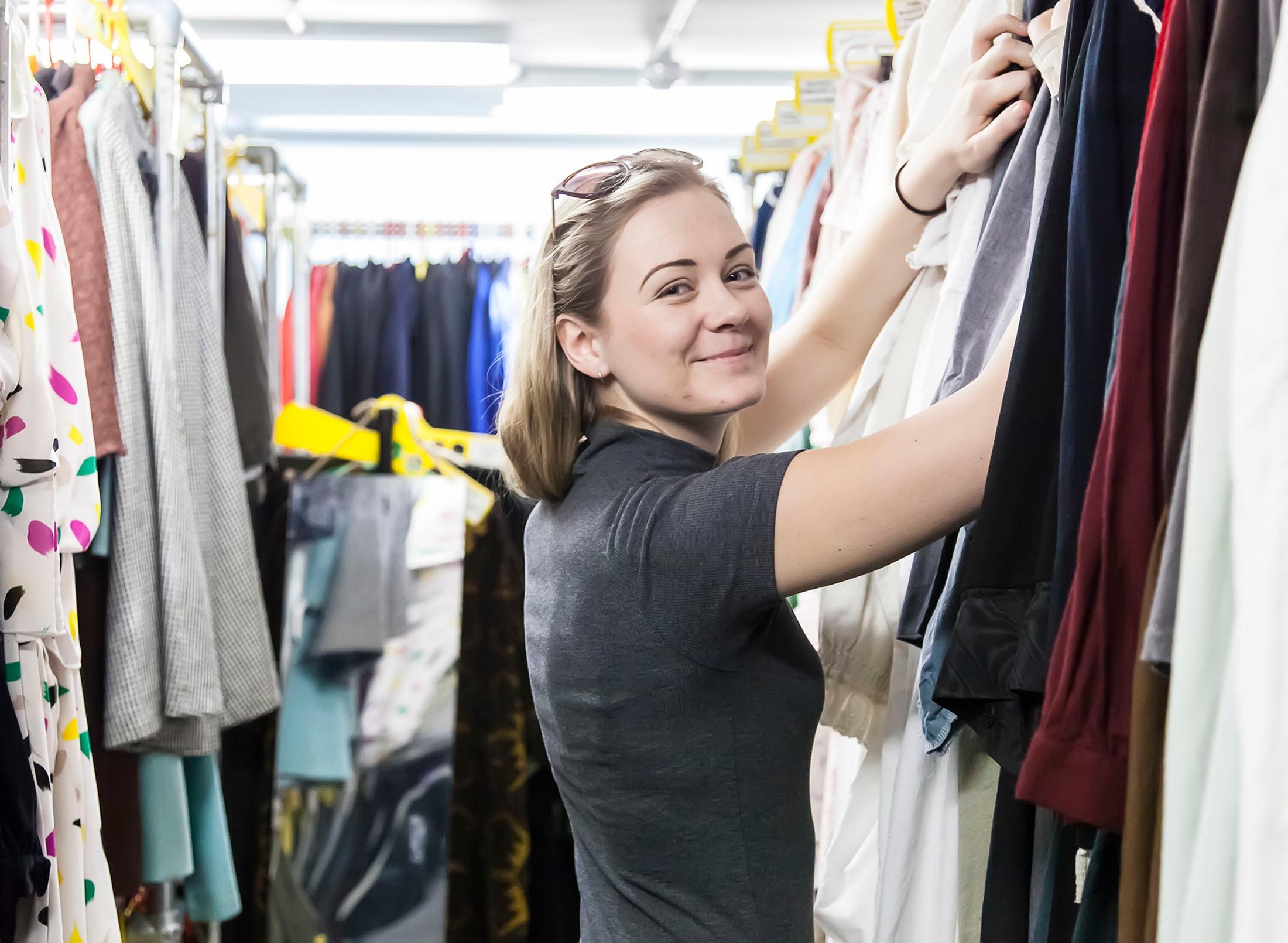 student in wardrobe room with clothes for theatrical production