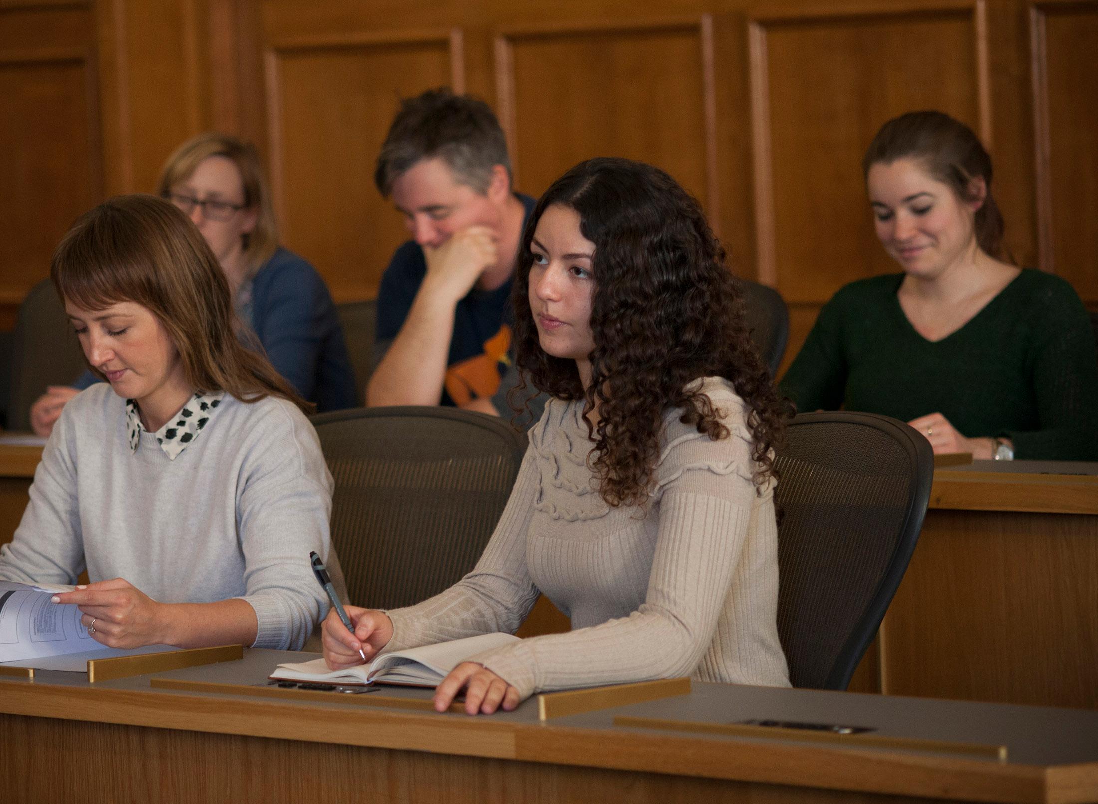 Row of students take notes in courtroom setting