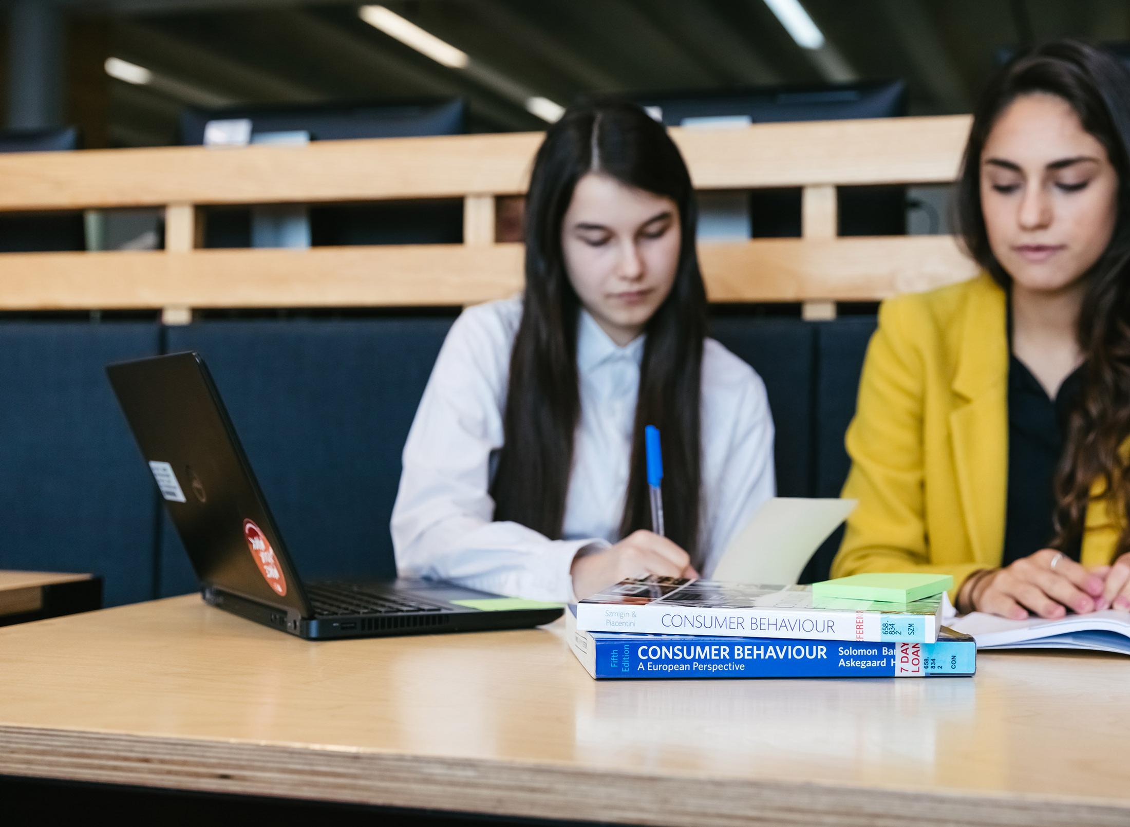 two students studying together with textbook