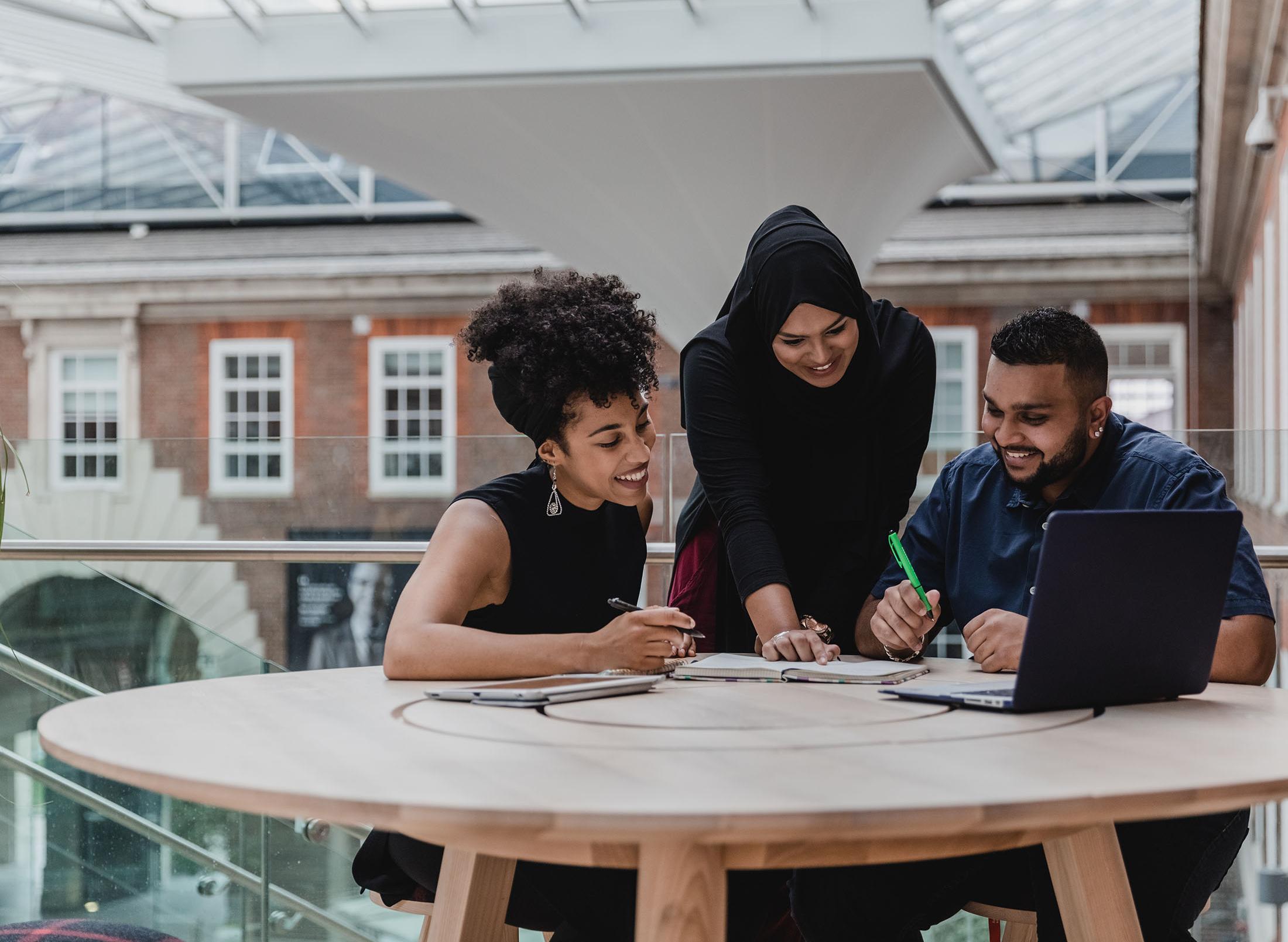 Three students working on a project together at a table