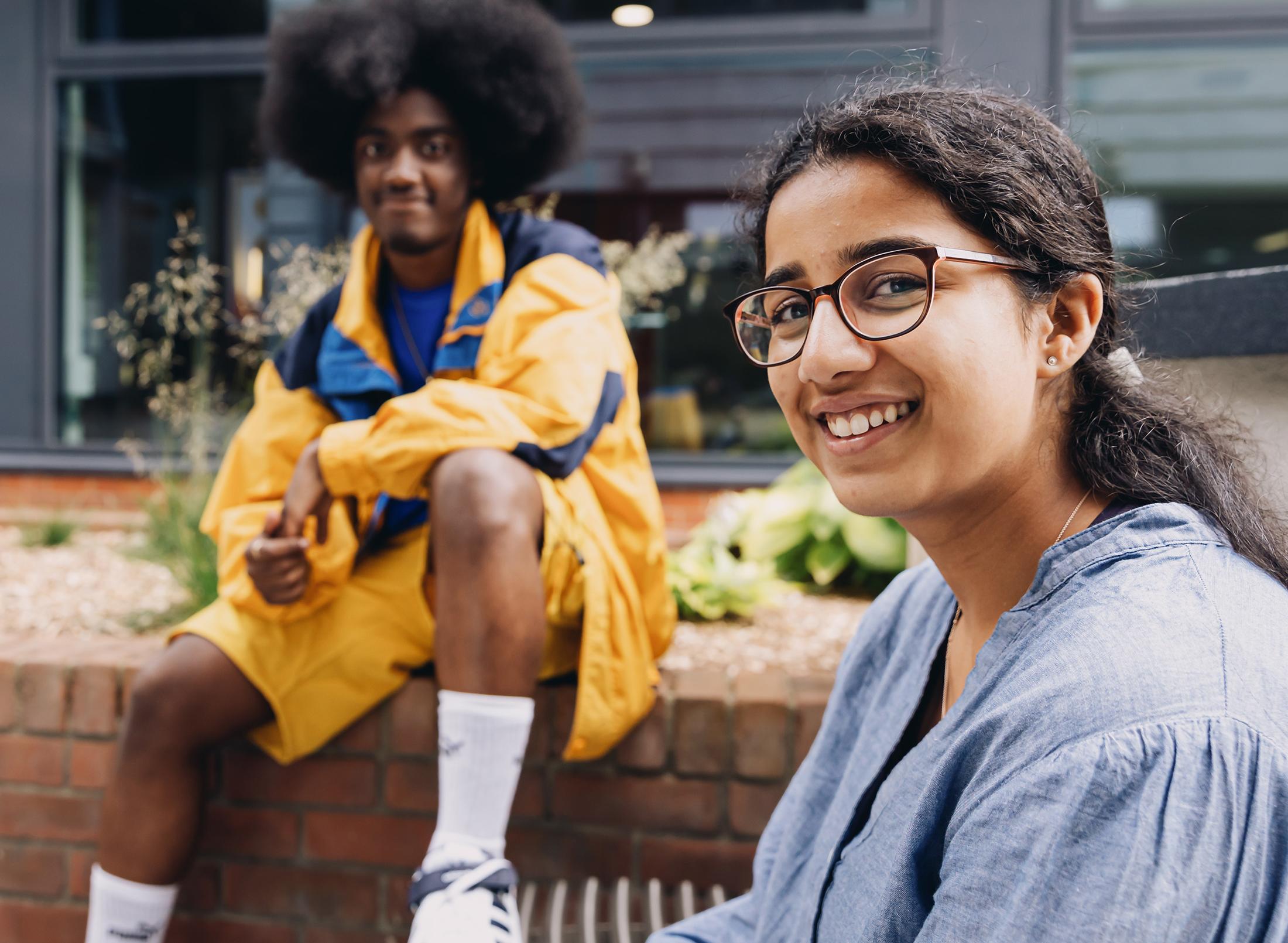 Male and female students sat on campus