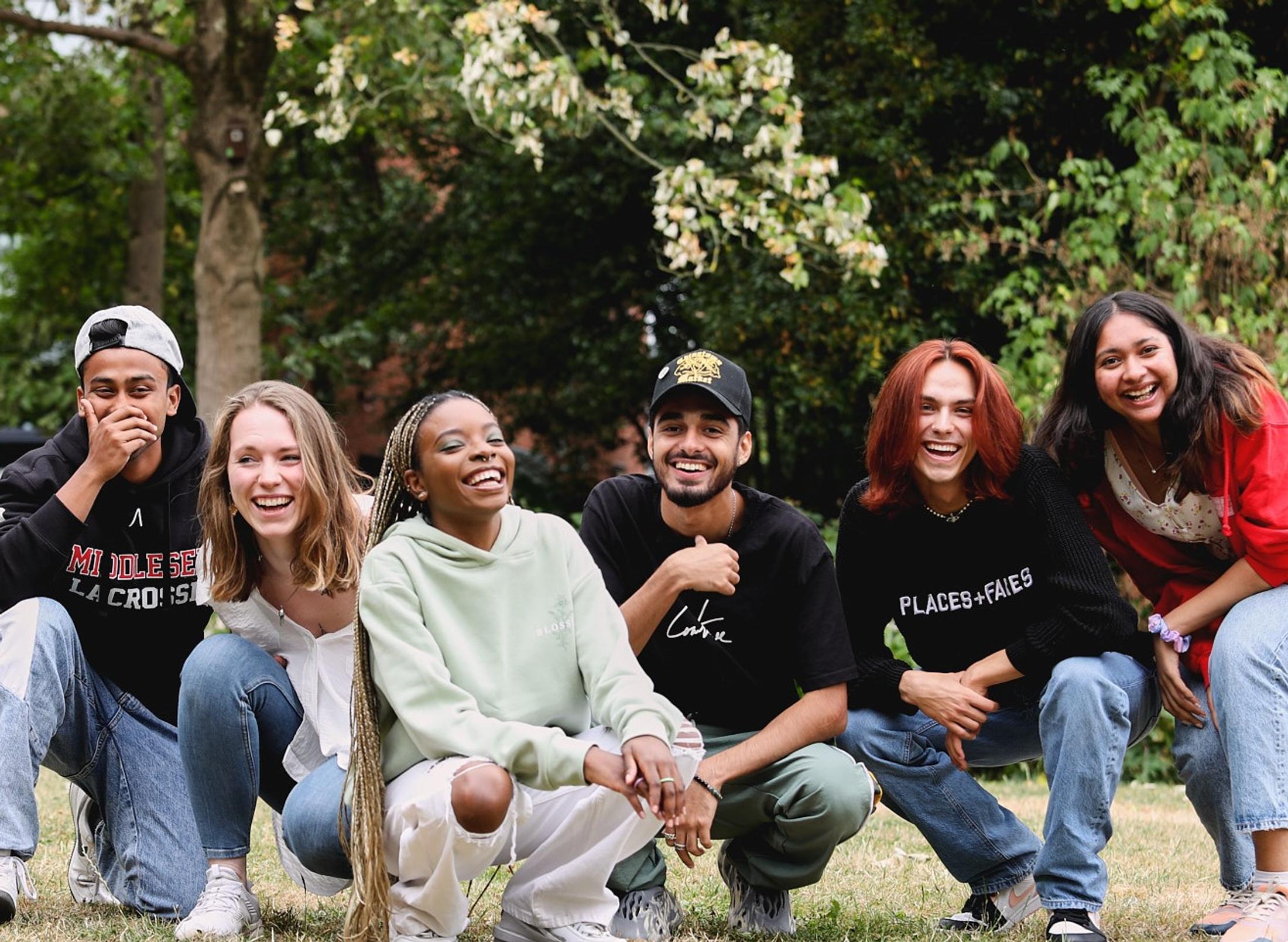 A group of young people smiling and posing together for a photograph, capturing a moment of camaraderie and friendship.