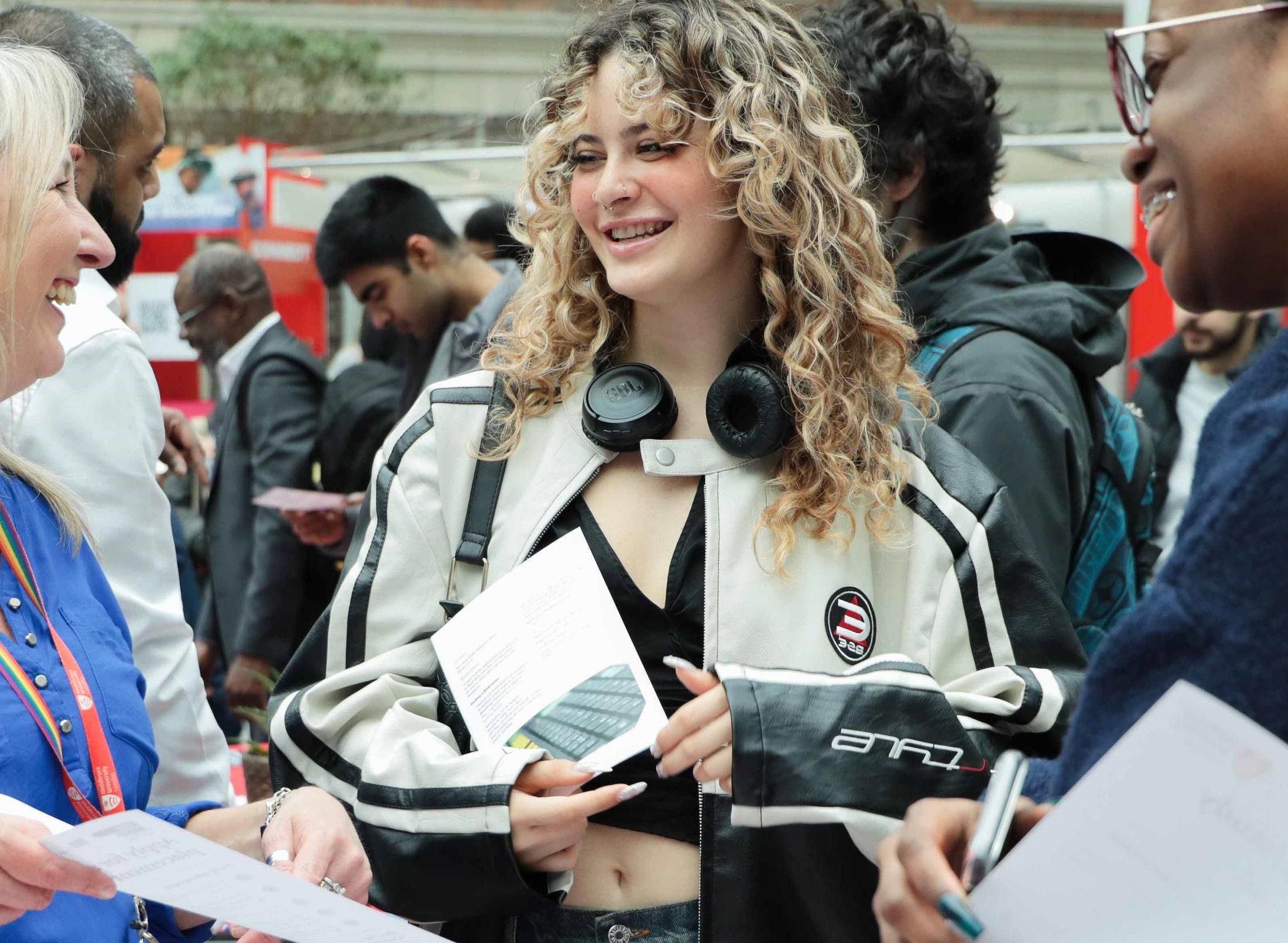 Three women engaged in conversation, exchanging information and networking.