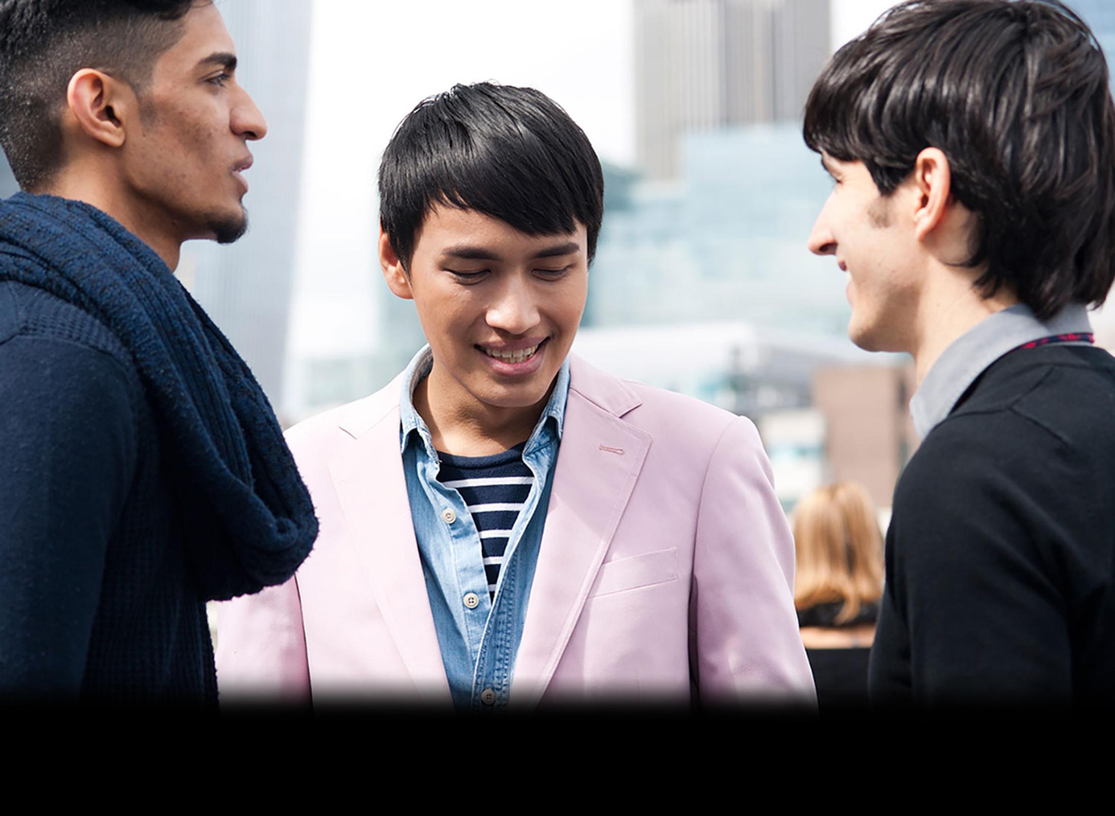 three students facing each other smiling