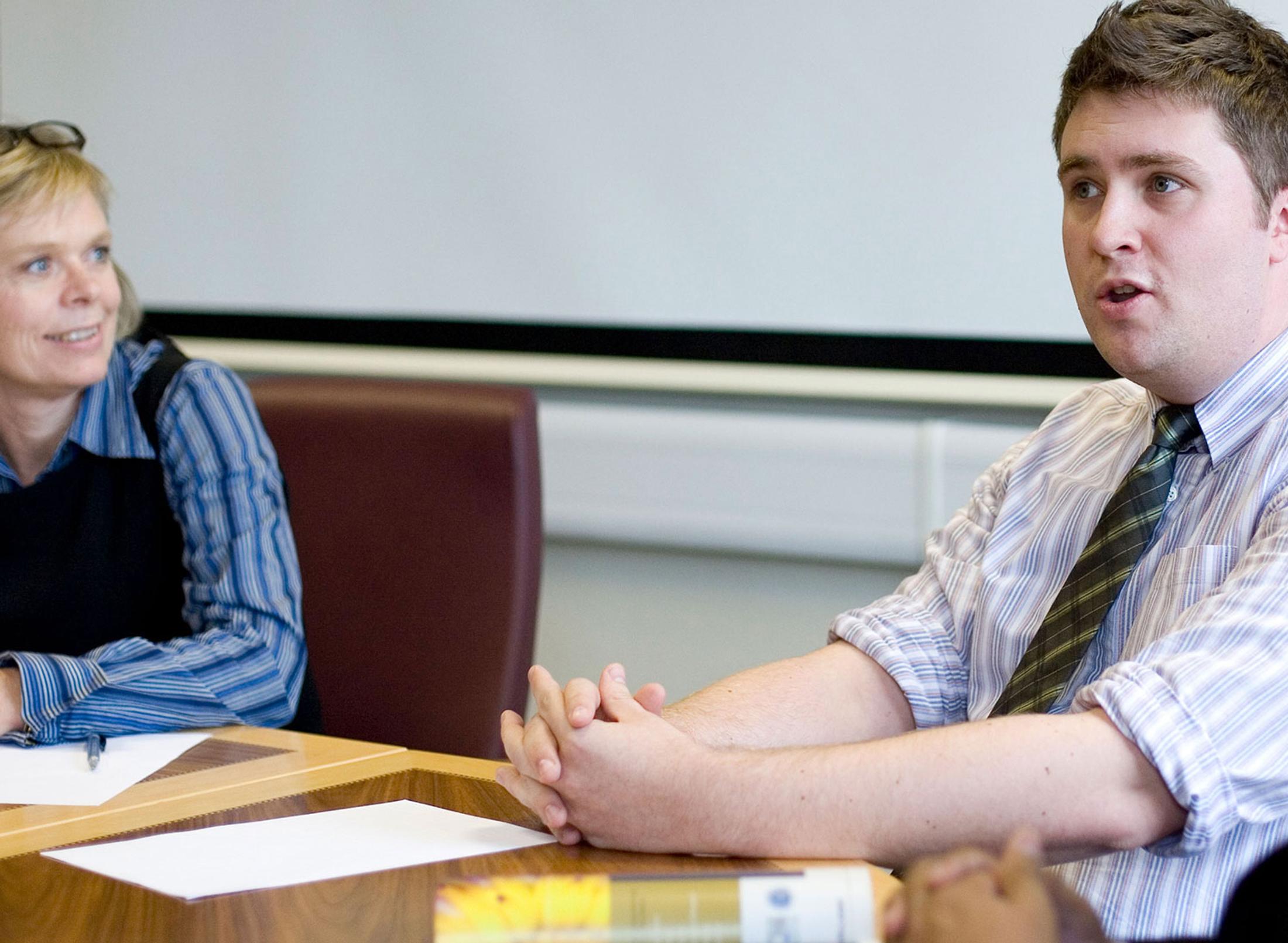 mature students in formal wear sat down in discussion