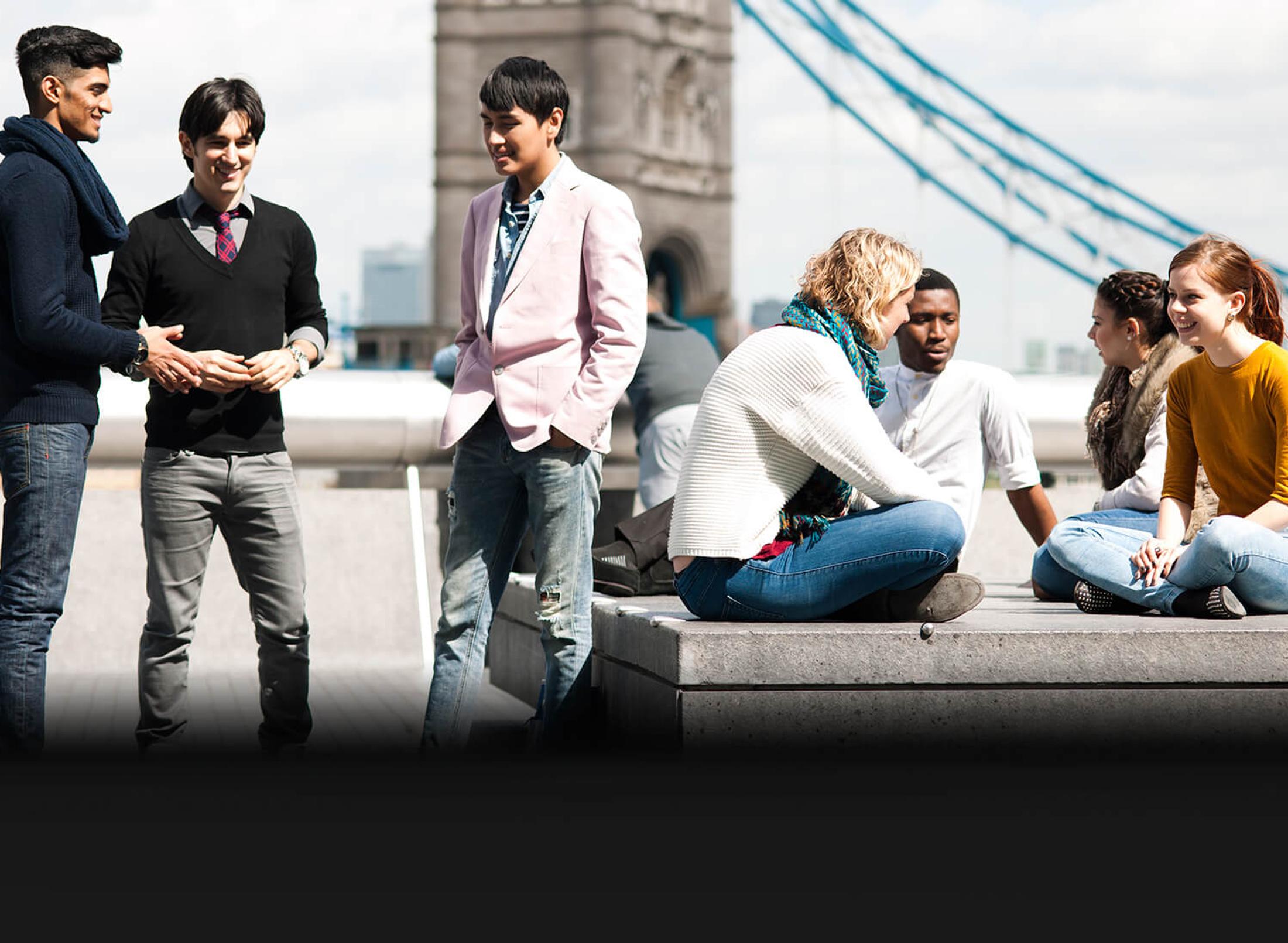 group students having conversation near tower bridge in London