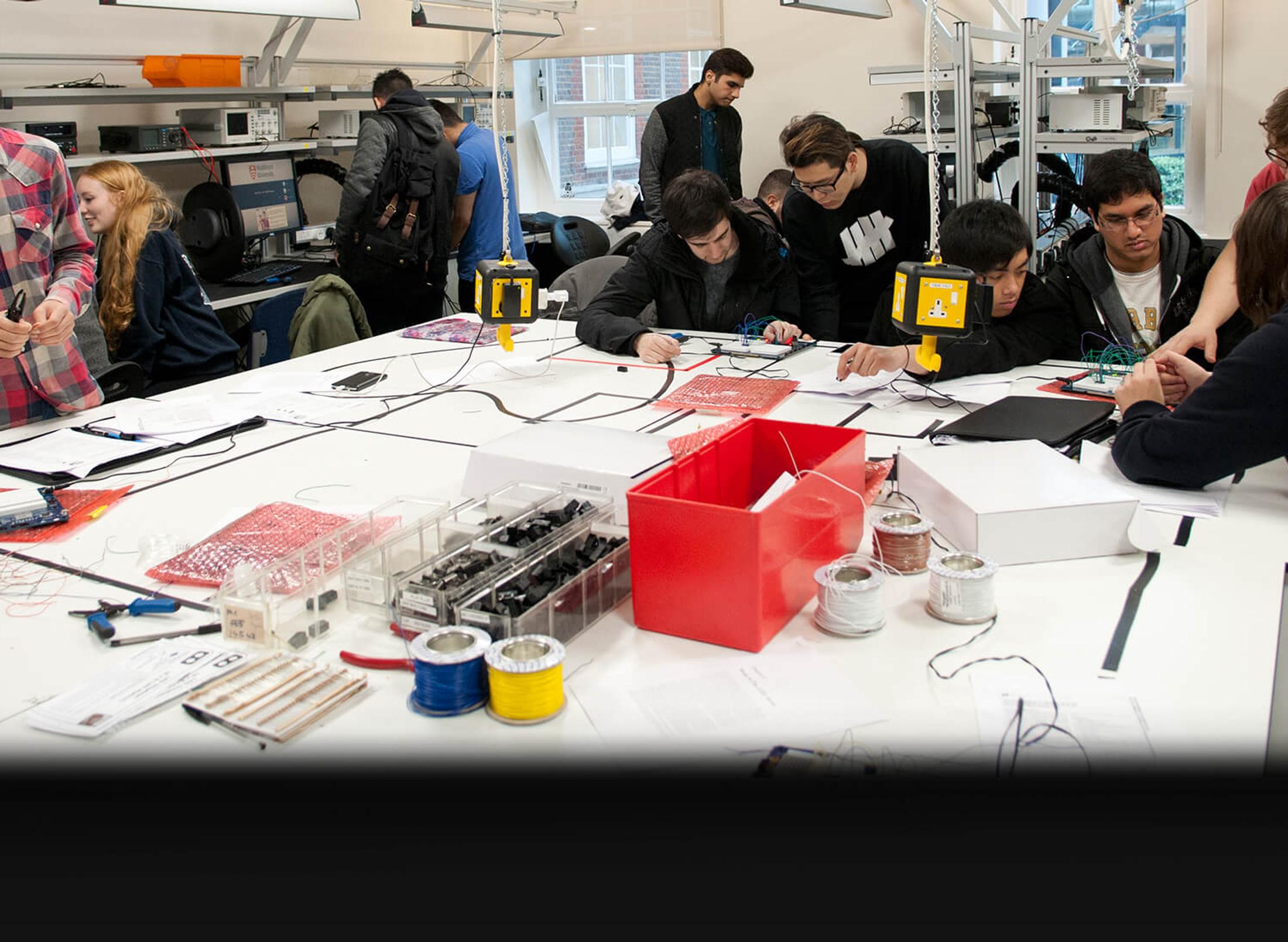 students work with circuit boards in busy laboratorys