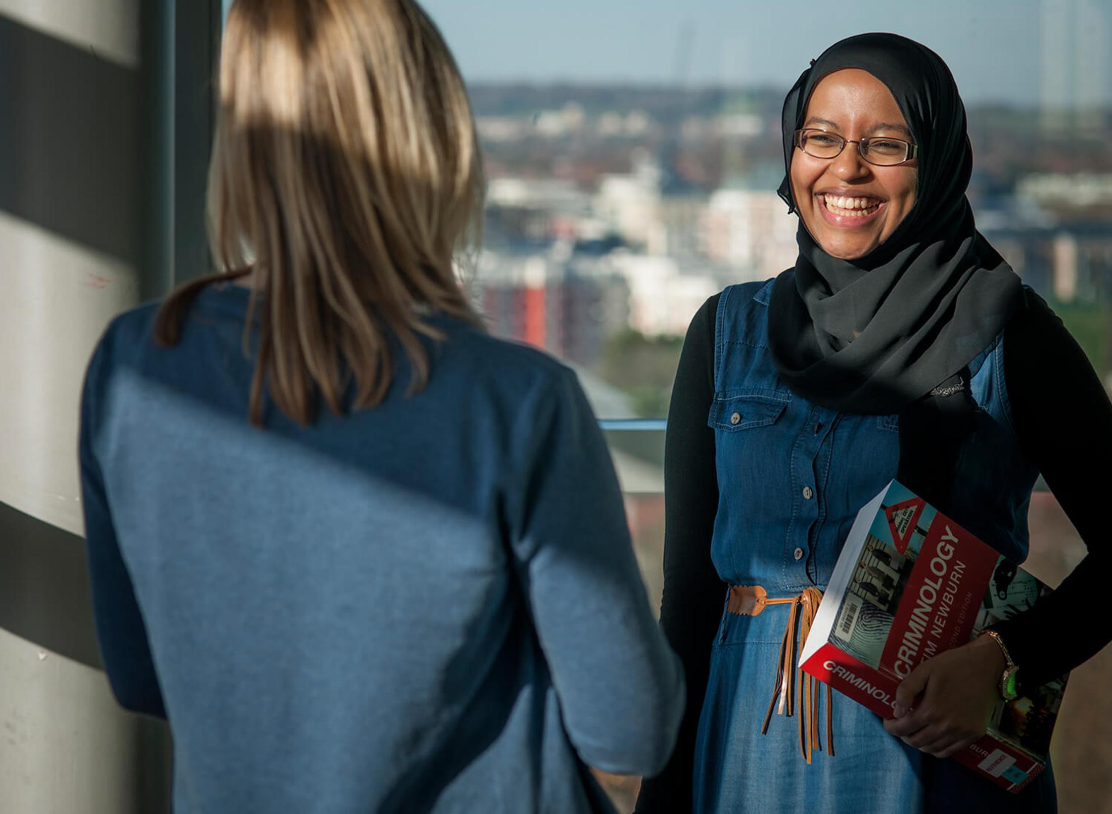 Two students chatting on campus on a sunny day