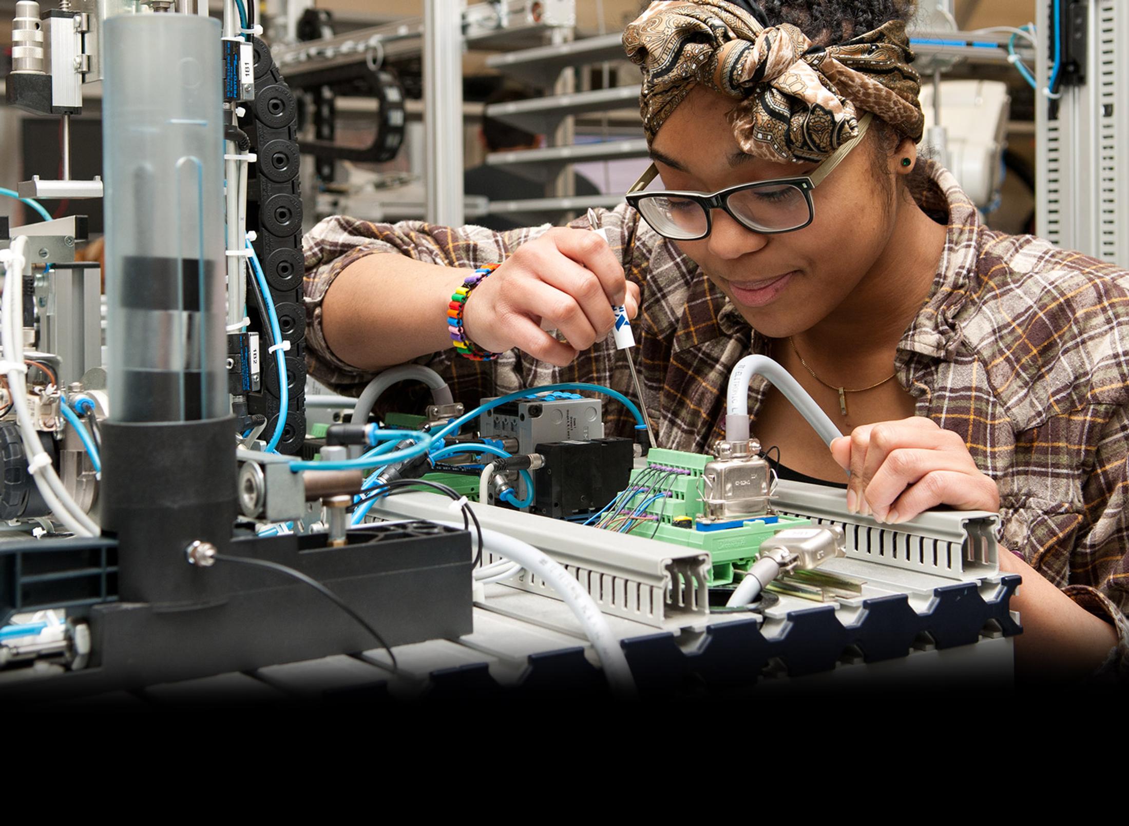 Female student working on engineering equipment in the MDX mechatronics lab
