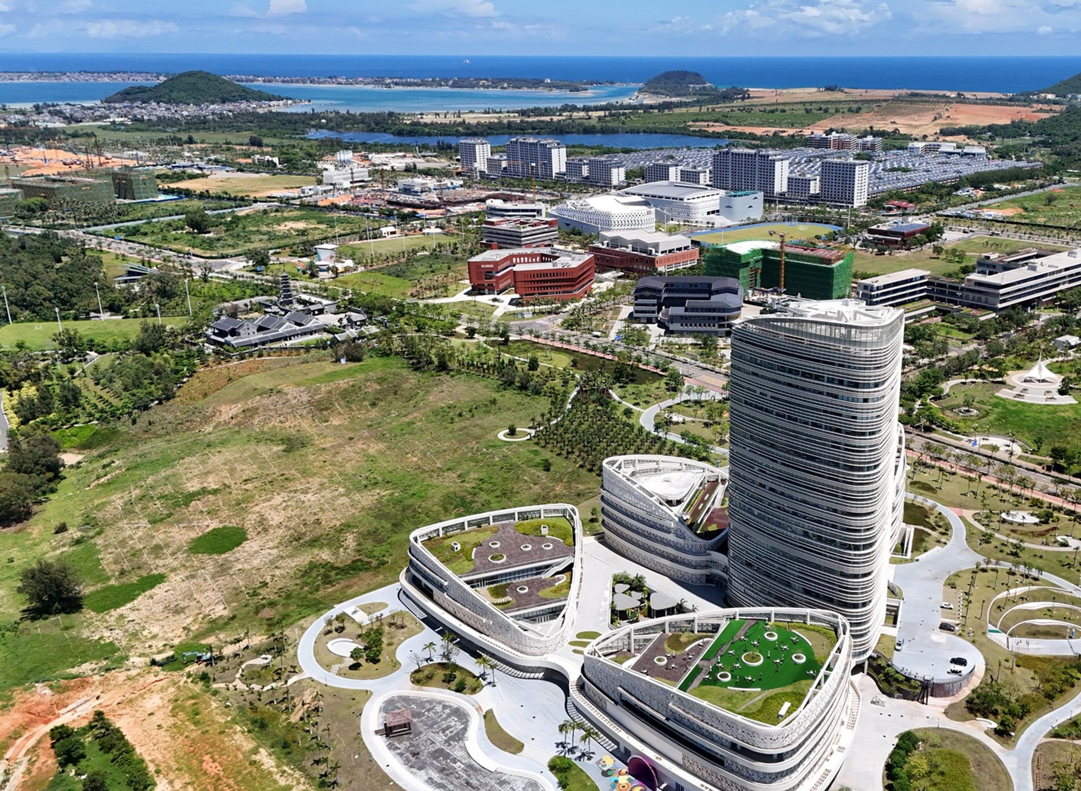 Aerial shot of the Hainan joint campus between Middlesex University London and Minzu University China, showing a tall tower against a green landscape