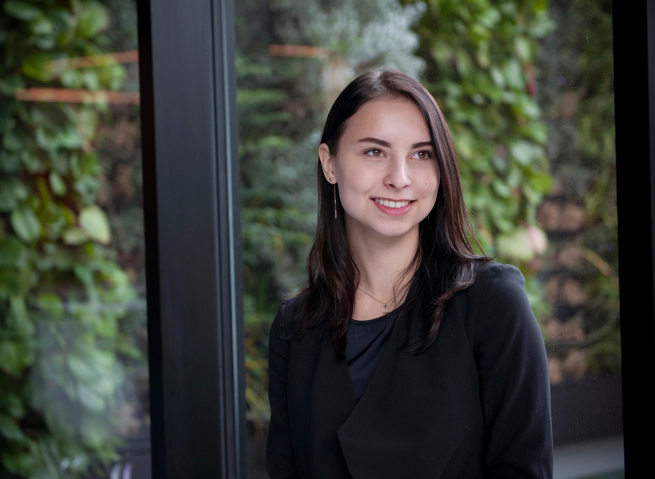 smartly dressed student, backdrop of large window looking out onto leafy background