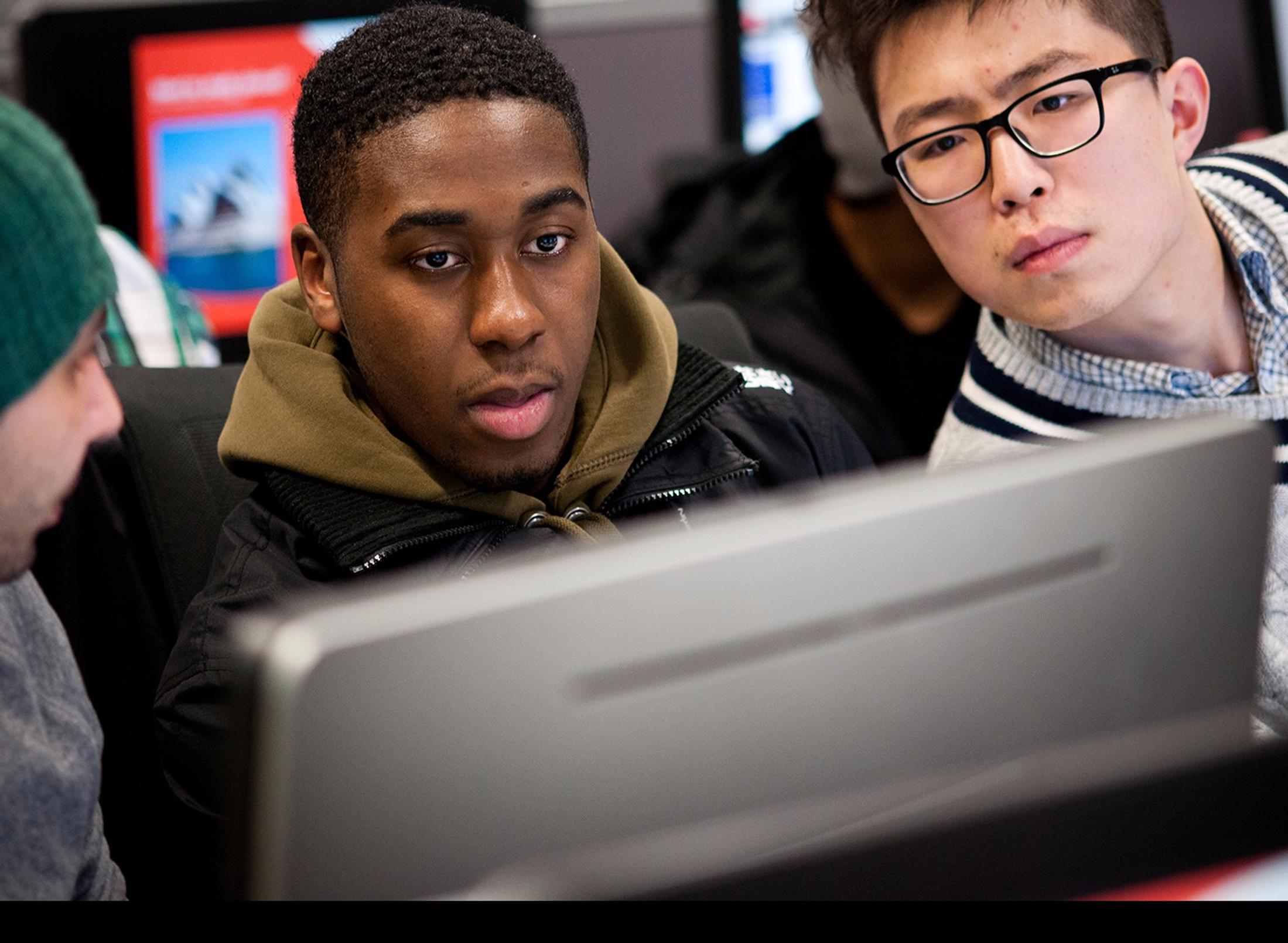 Group of students huddled over a computer