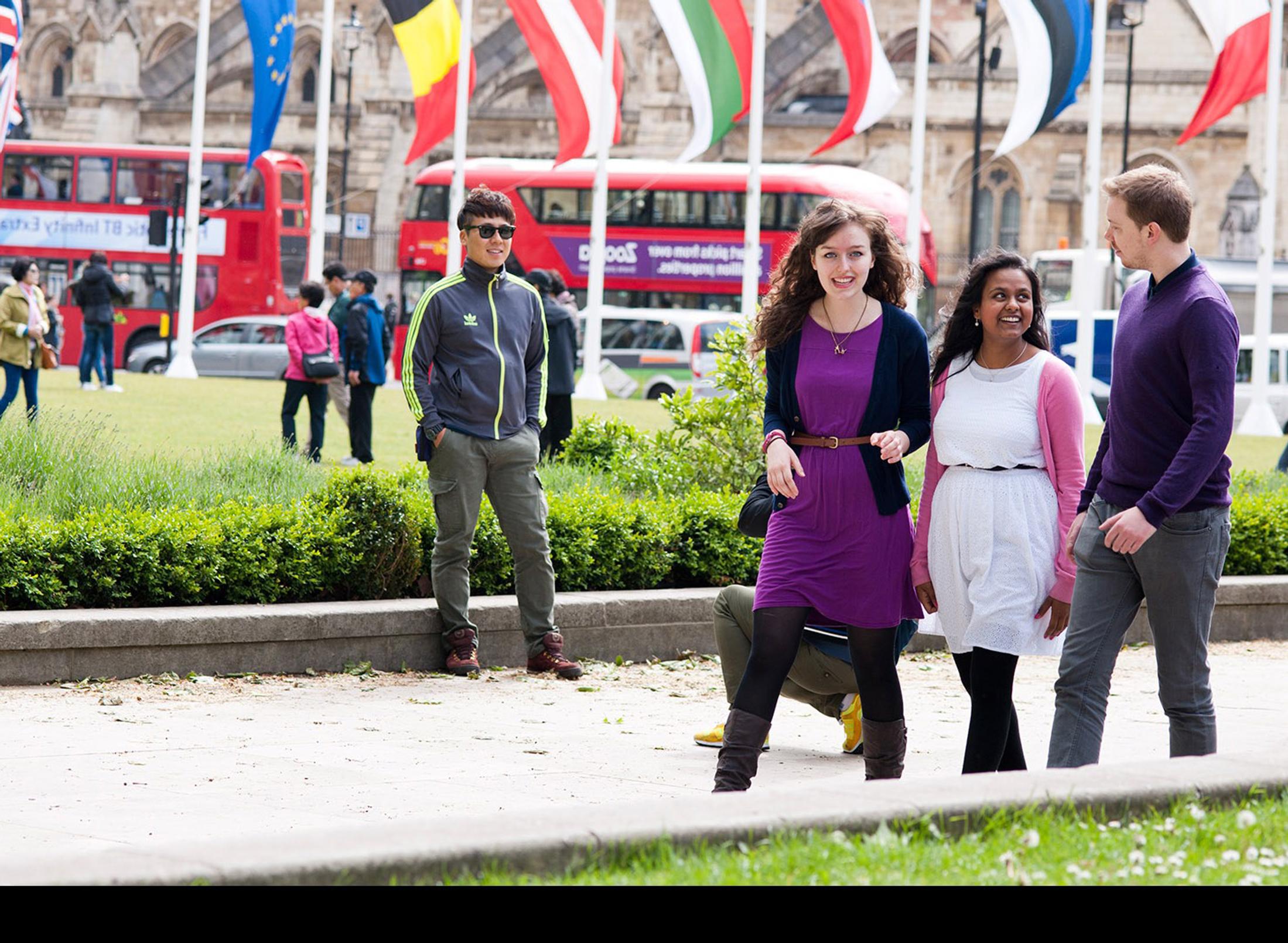 Three young people walking in a park, enjoying nature and each other's company. A perfect representation of international tourism and hospitality.