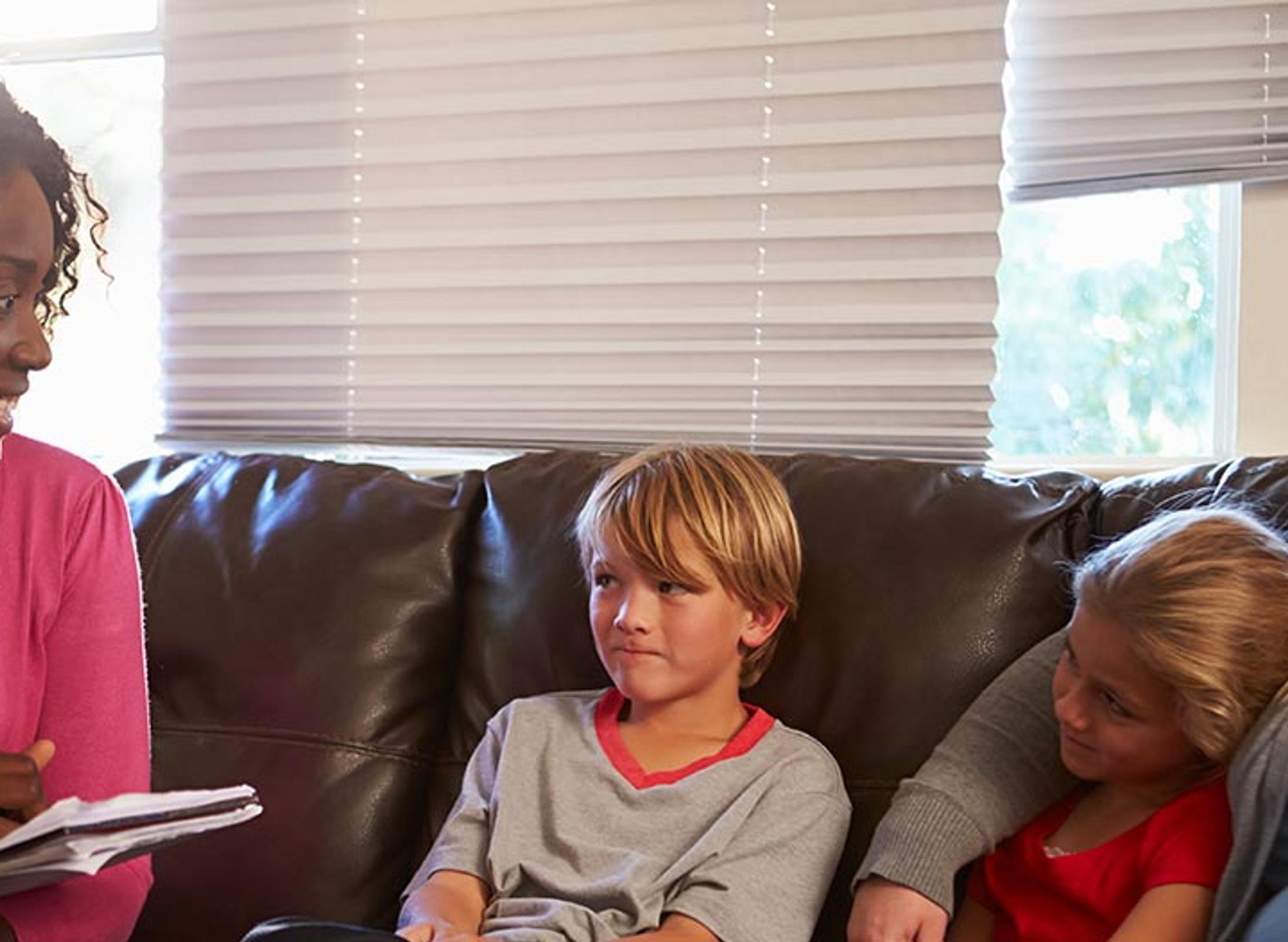 two ladies sat on a sofa with social worker