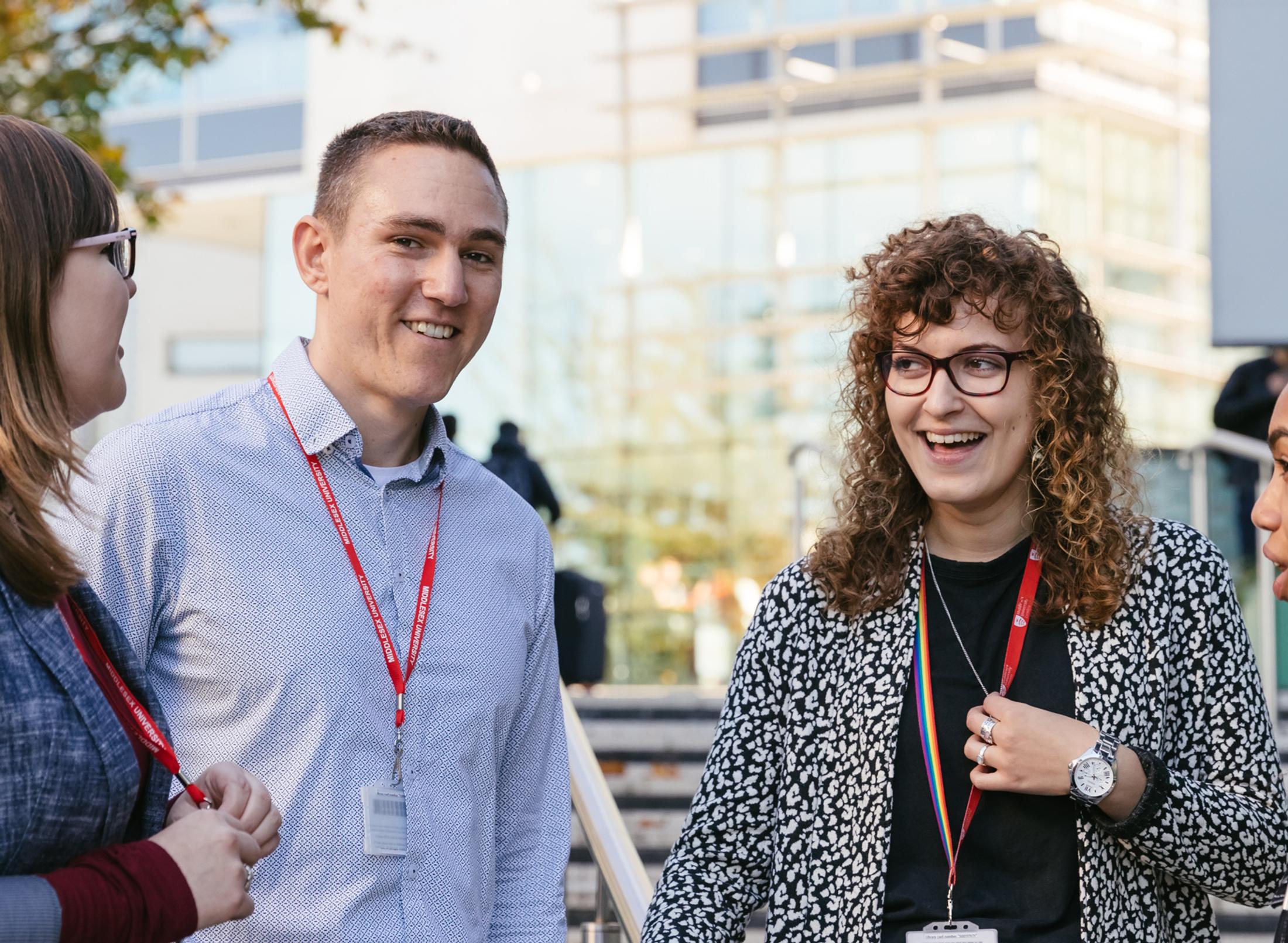 A group of adults talking outside a modern building