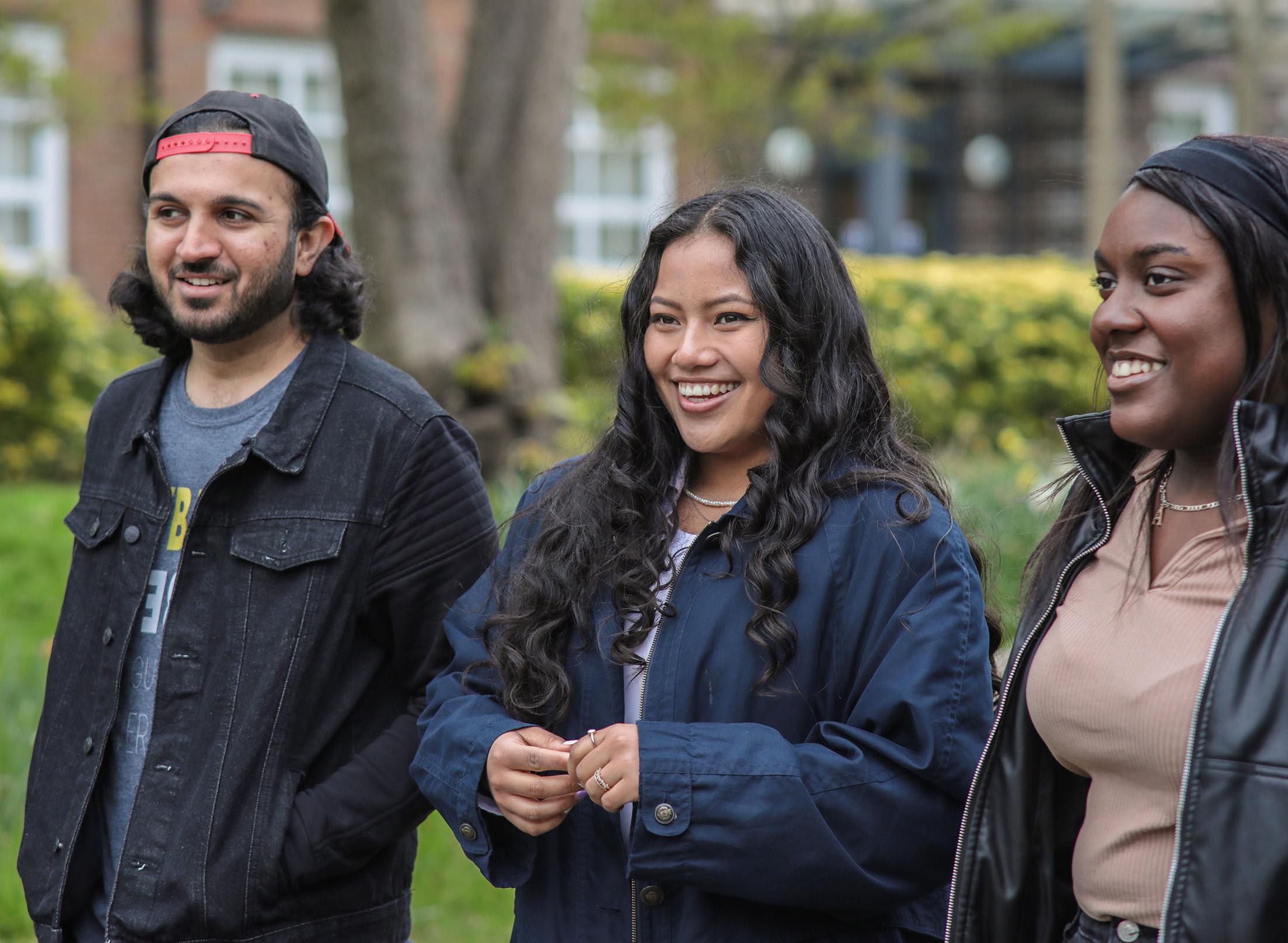 three students walking through park