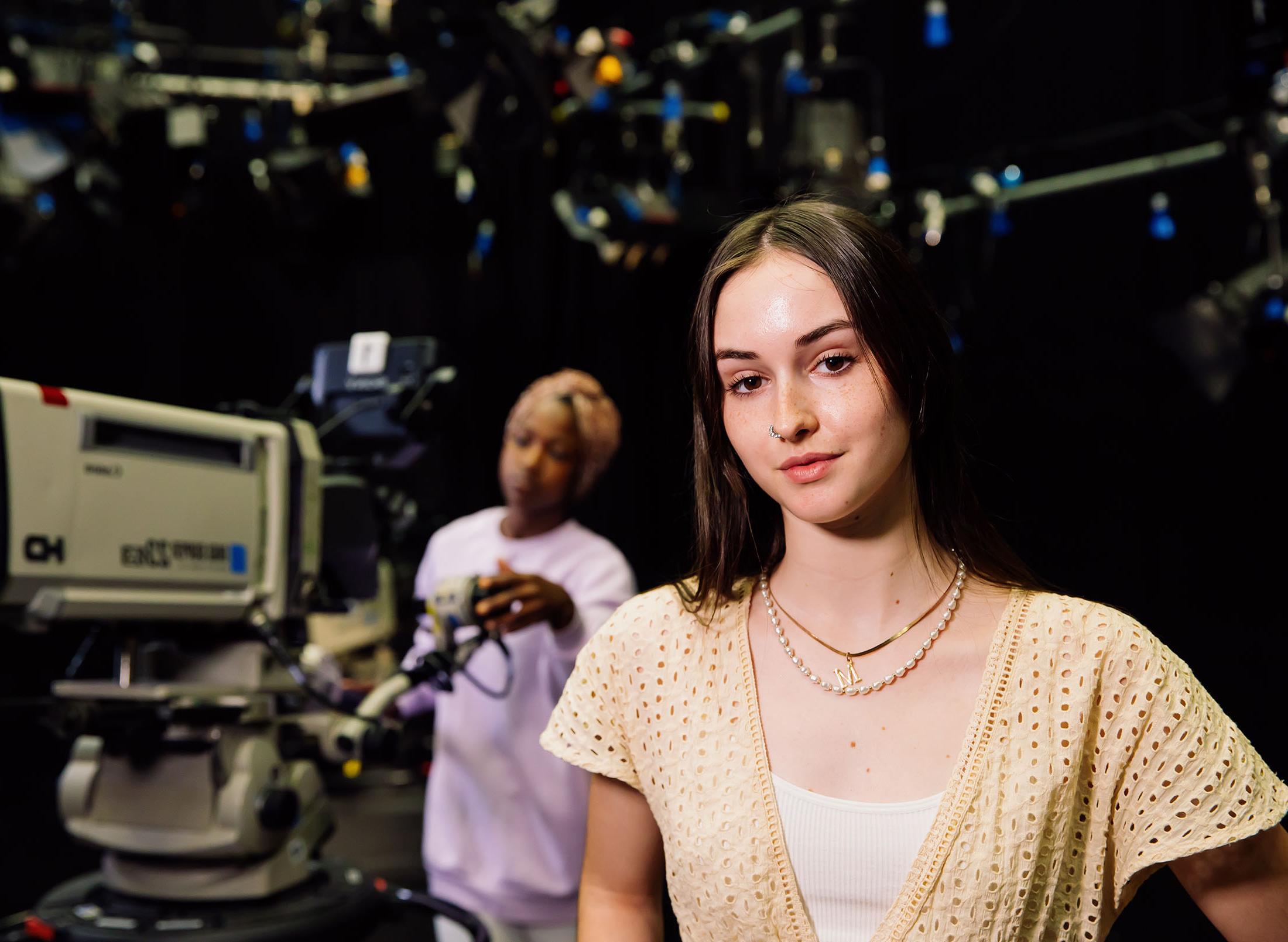 Two students on set with large camera