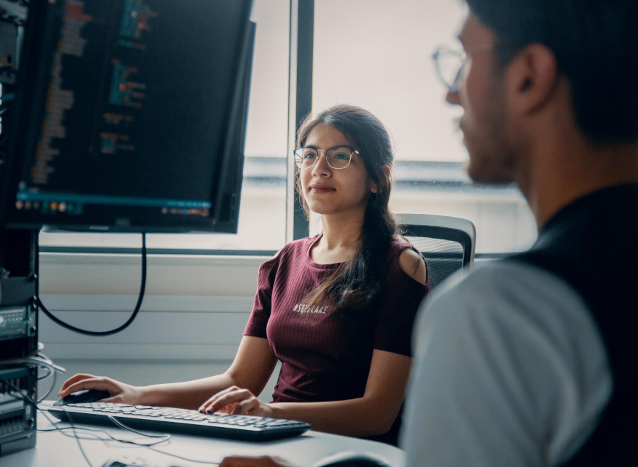 A student typing on a keyboard in front of a monitor