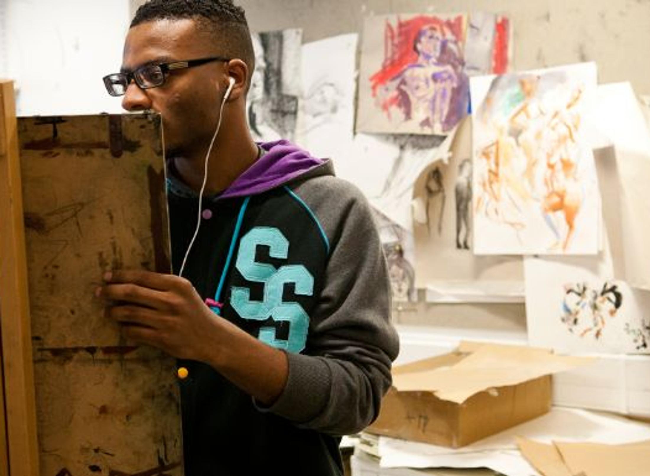 black student painting on easel