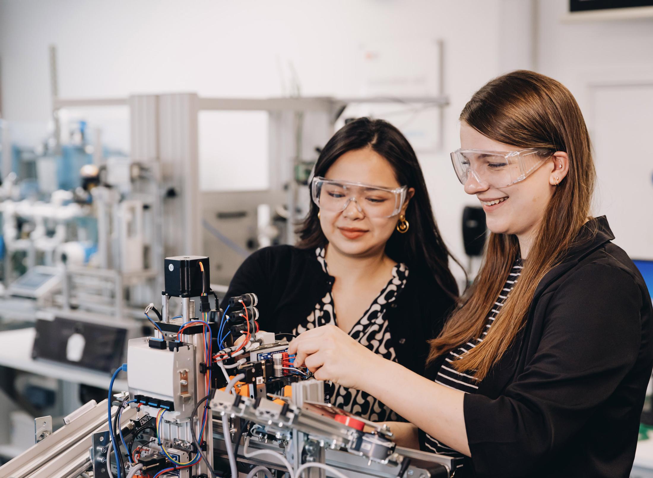 Two students working on a robot arm