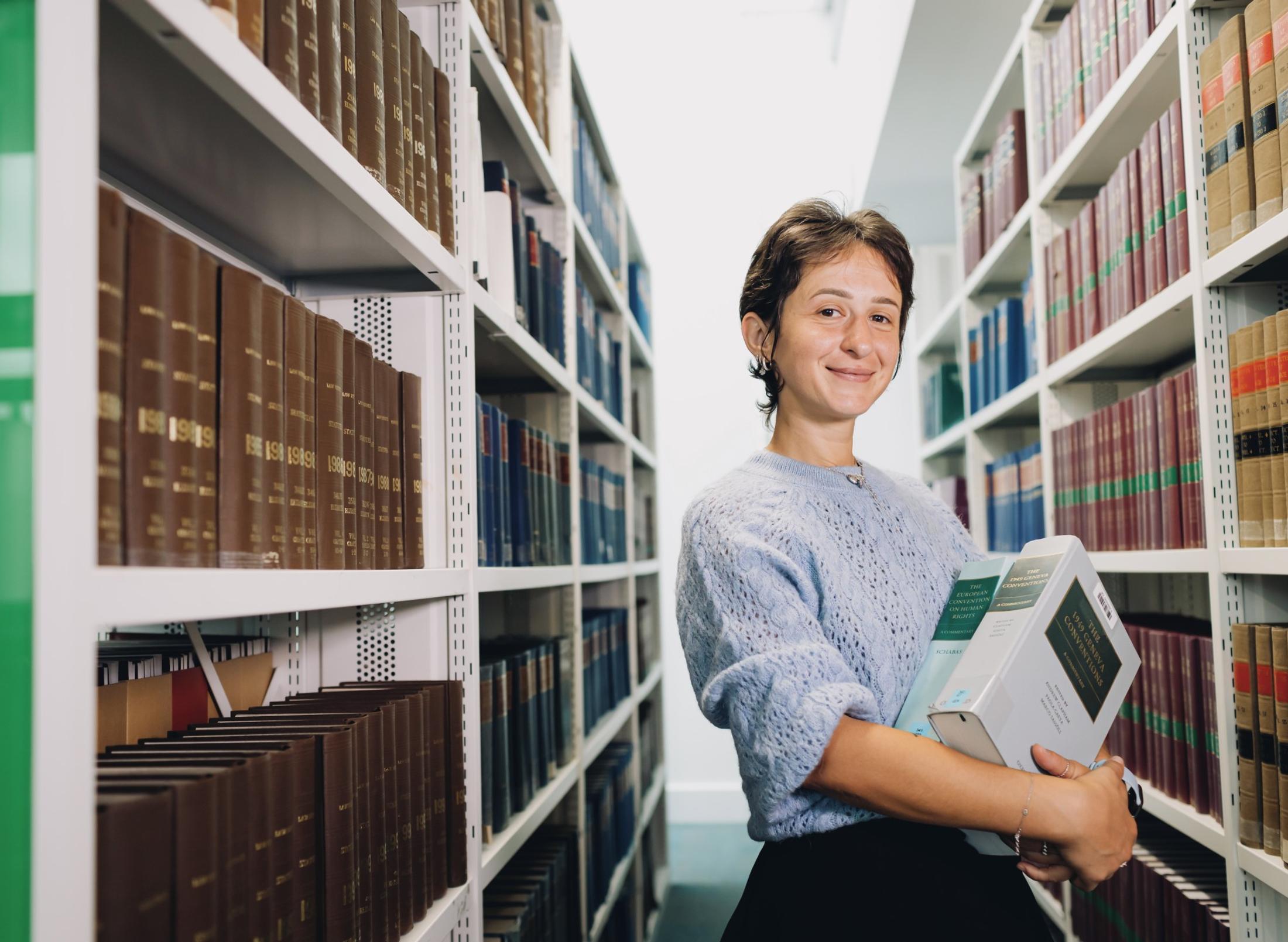female middlesex university student in the sheppard library carrying books