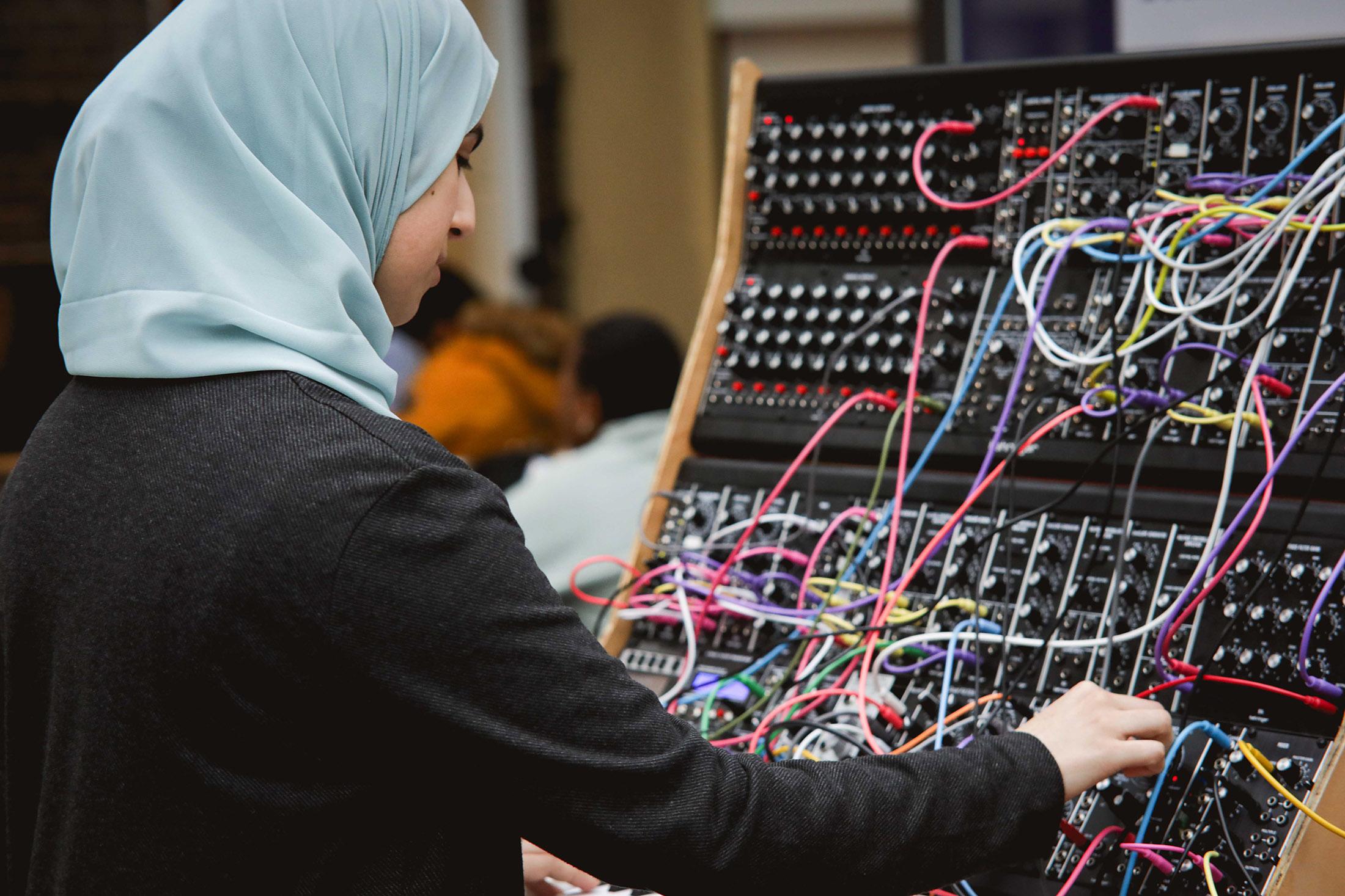 young student interacts with complex switchboard