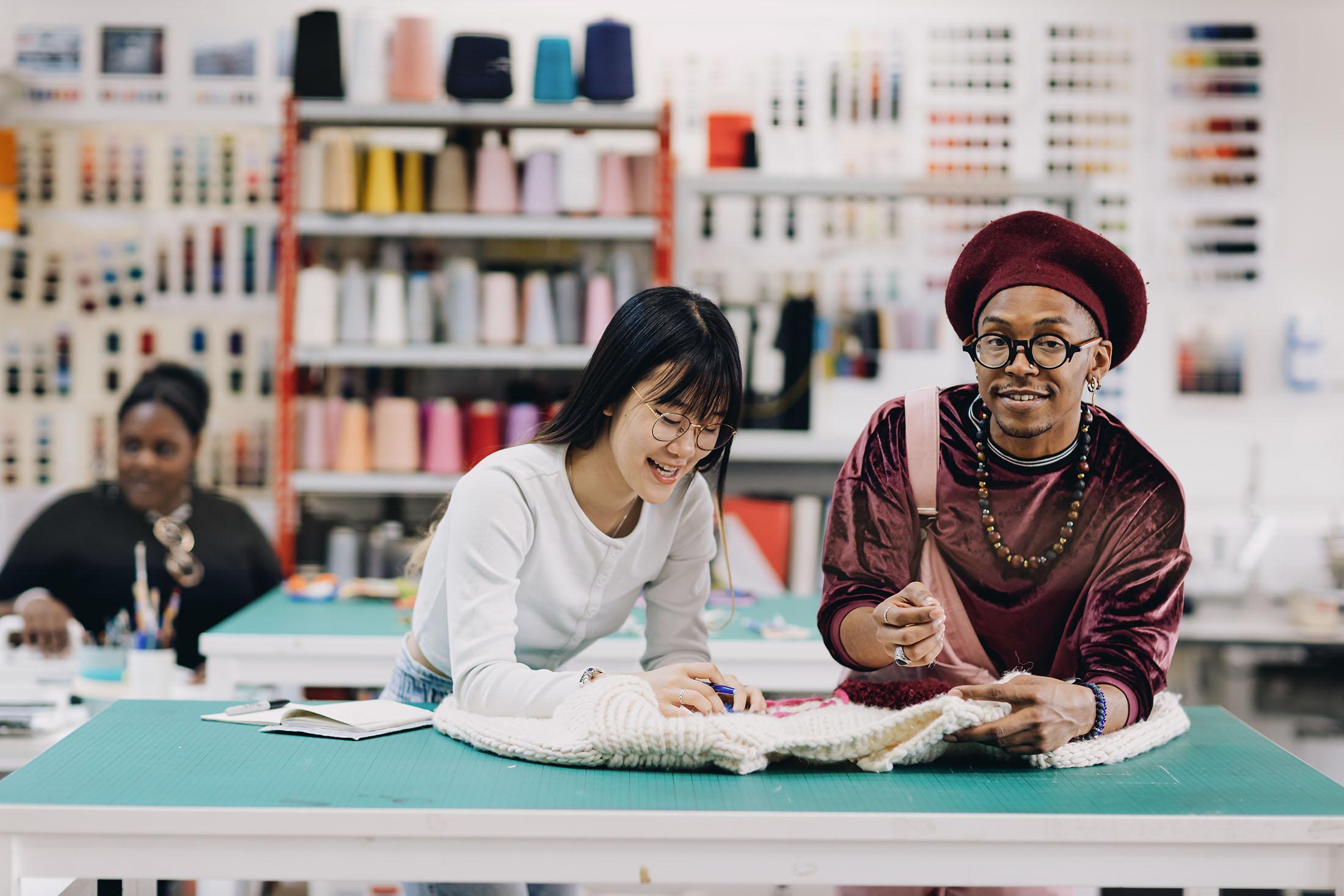 two stylish students working together in fashion workshop