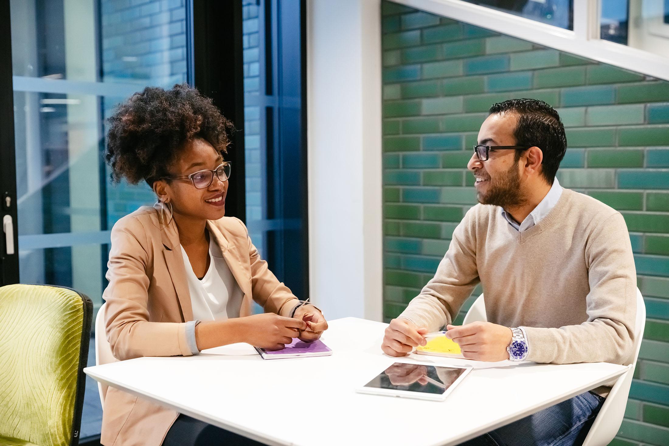 two students have discussion at table