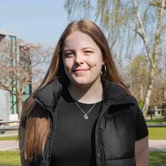 Abbi on campus on a sunny day with building in background