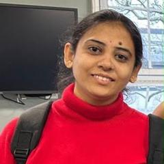 Portrait of Naga Deepika, a Middlesex University graduate, wearing a red jumper and backpack during a work experience and employability skills programme.