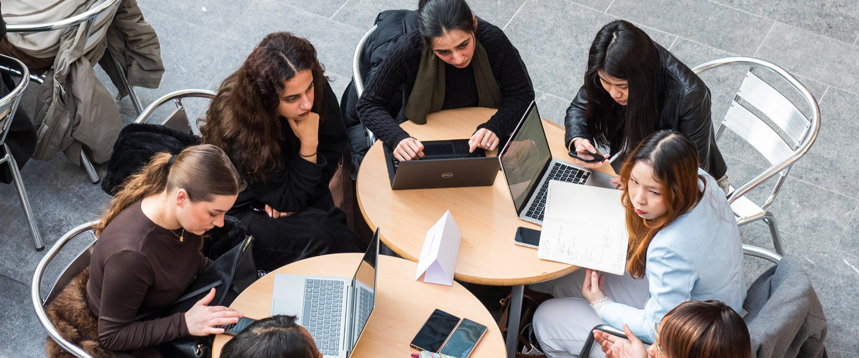 A group of young women in a discussion round a table taken from above