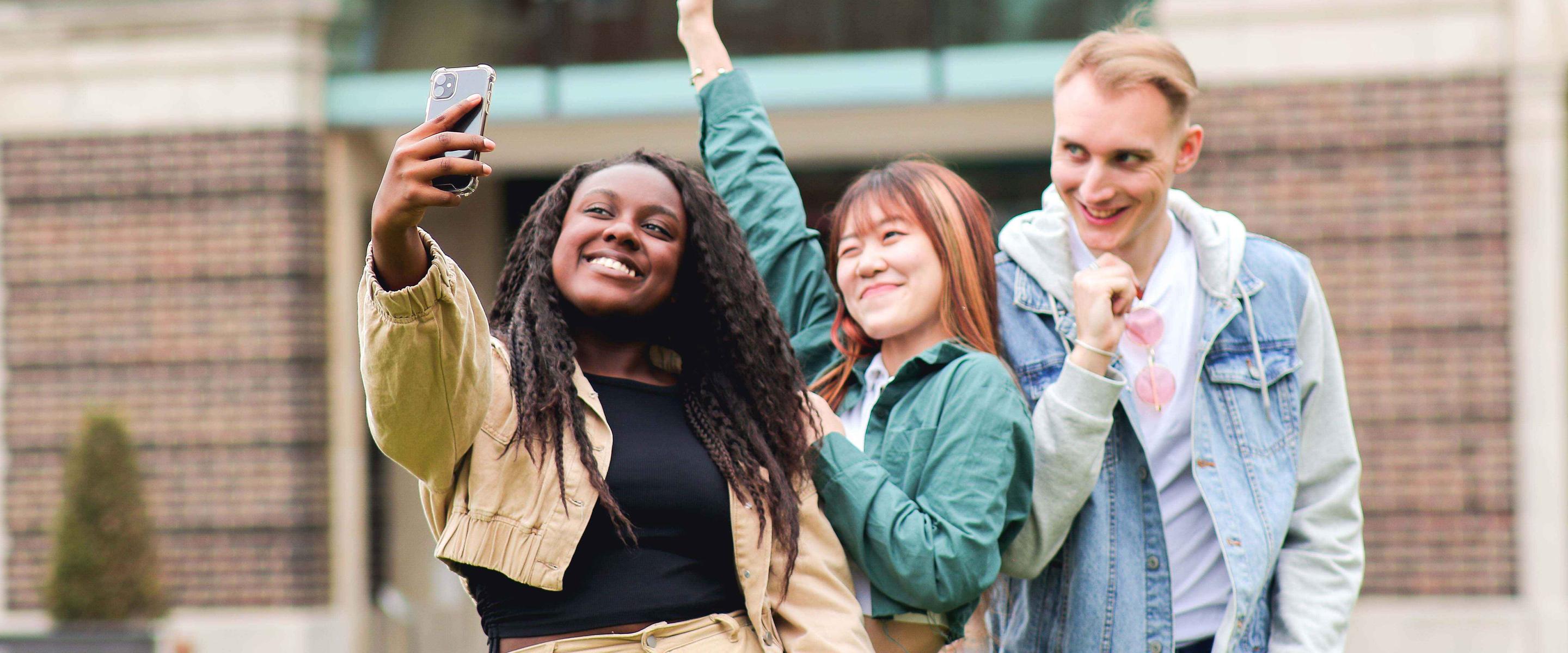 Three students on campus taking a selfie