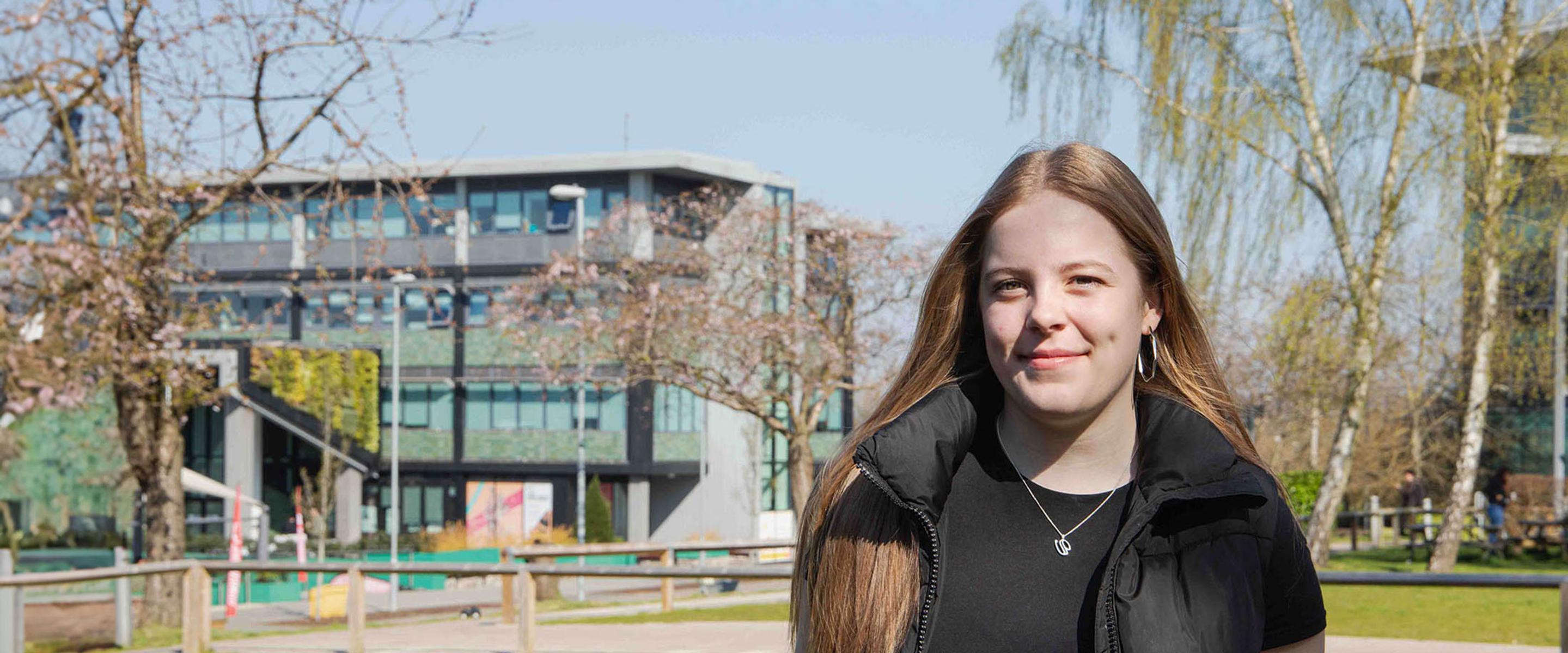 Student Abbi stood on campus on a sunny day