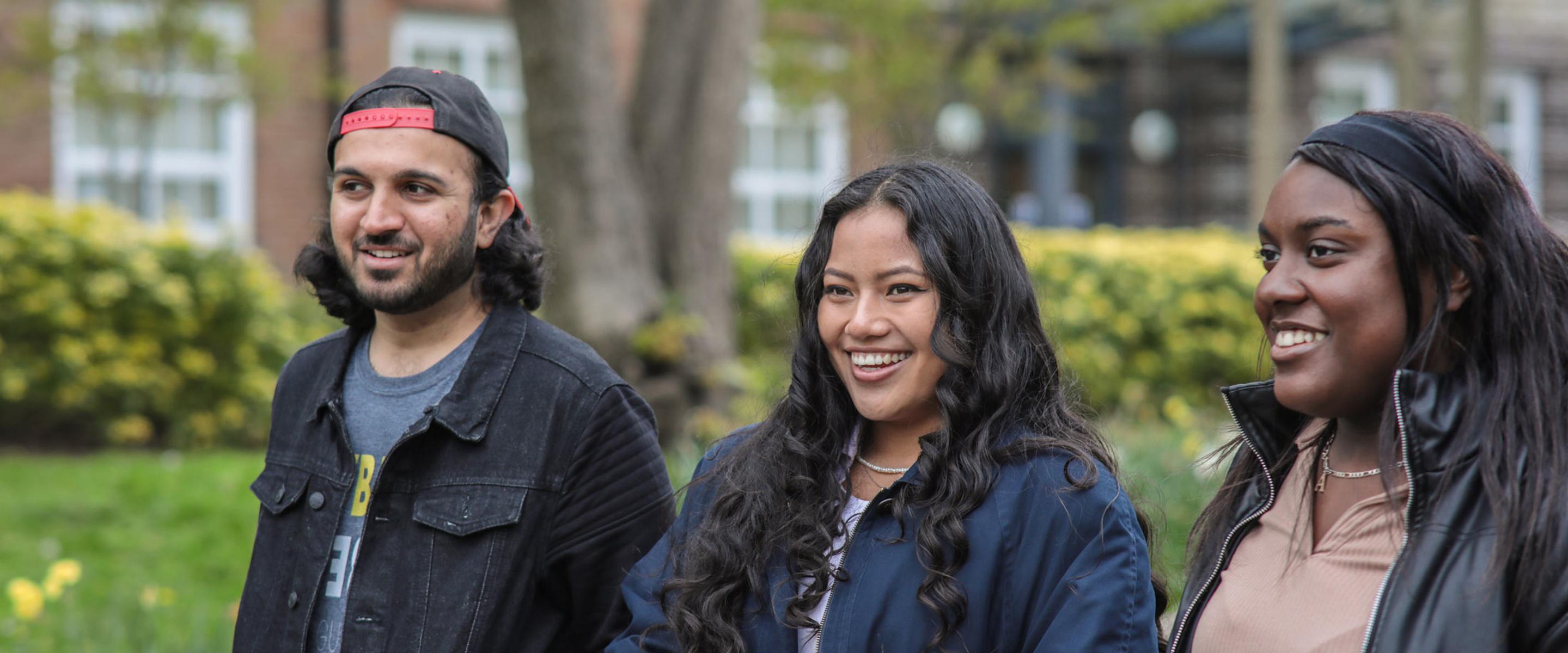 Three students walking around campus