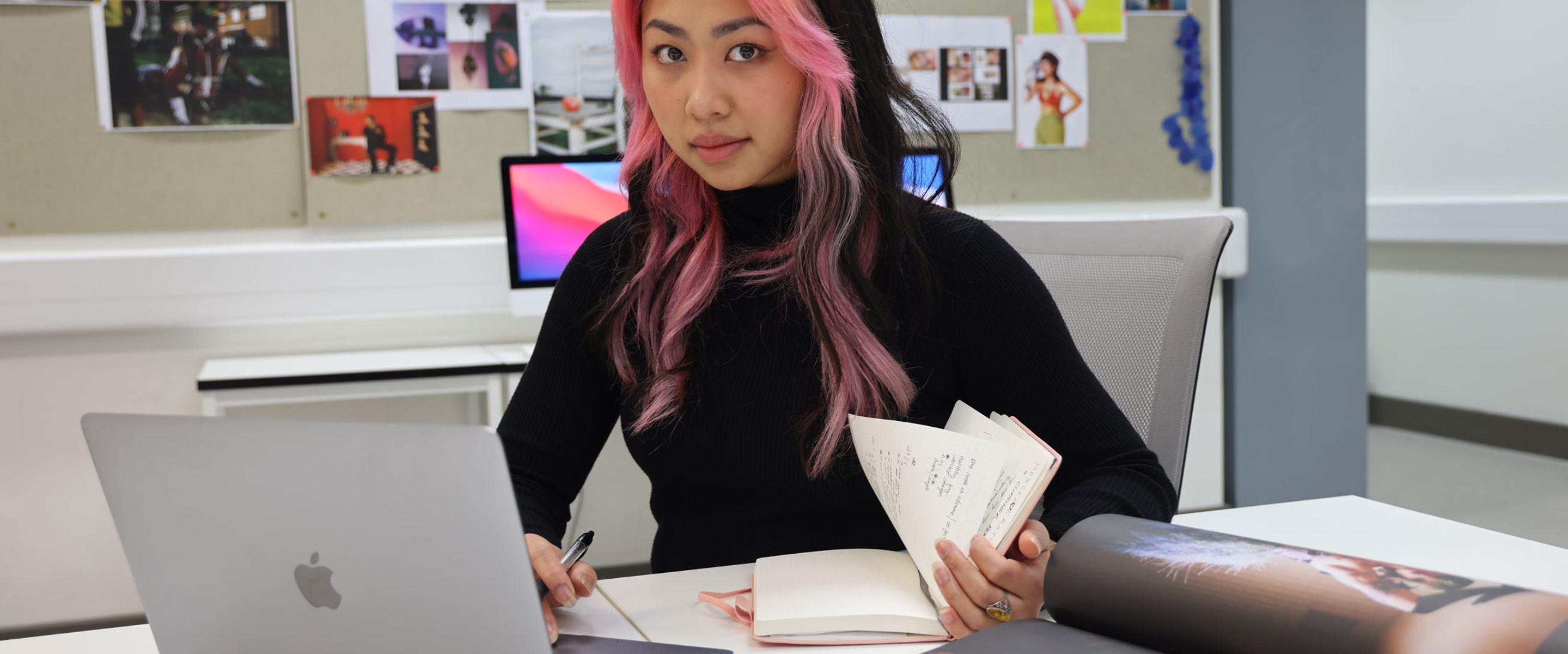 Marketing student sat at desk using laptop