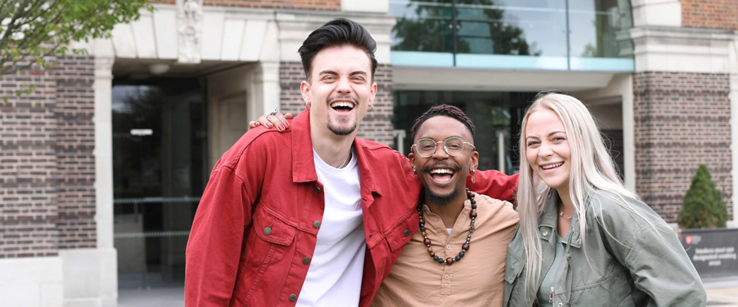 Three students laughing outside Middlesex University, London