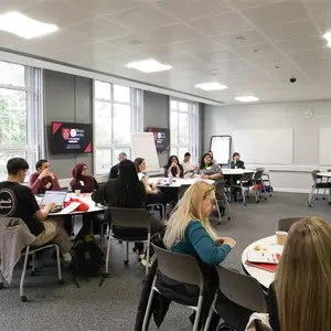Teachers at the careers convention sitting down at tables talking.