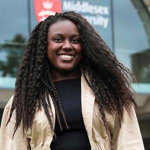 Student with curly long hair smiling at the camera