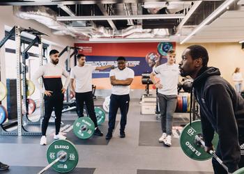 Students taking part in gym strength exercise.