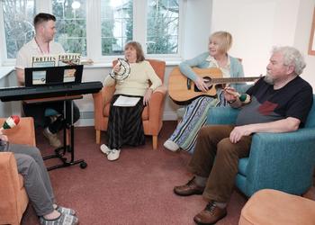 Group of people taking part in music session.