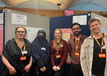 Five people standing and smiling at the camera