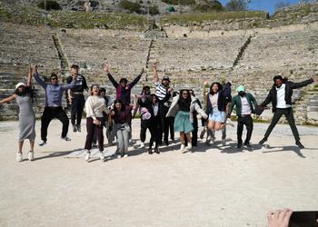 Students jump in the air at an ampitheatre