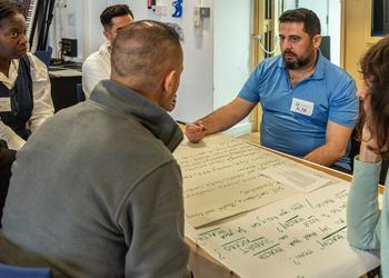 People sat a table looking at a big sheet of paper
