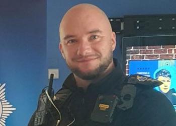 A police officer looks at the camera