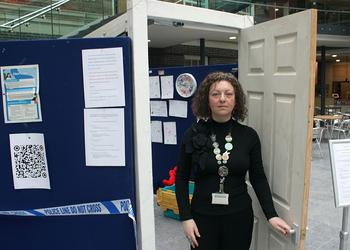 A woman stands outside an exhibition room