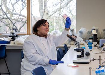 A female scientist in a lab holds up a tube