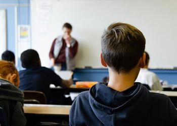 A boy sits in a classroom during a lesson