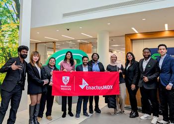 A team of students hold up a banner