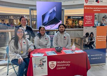 Students at a stand offering tax advice in a shopping centre